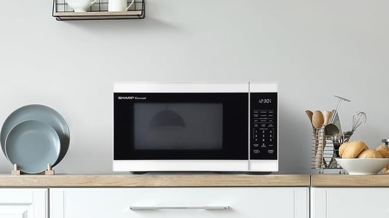 Sharp microwave sitting on counter in plain kitchen