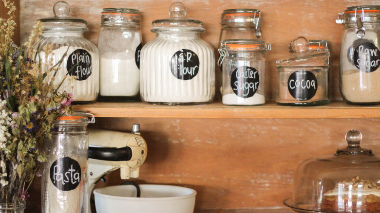 Jars of various baking ingredients in a pantry.