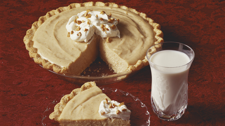 Pie with whipped cream topping and a glass of milk