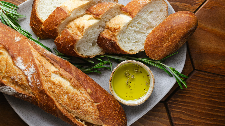 A French baguette with olive oil on a table