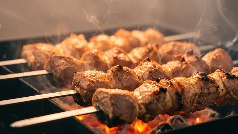 chicken skewers over coals