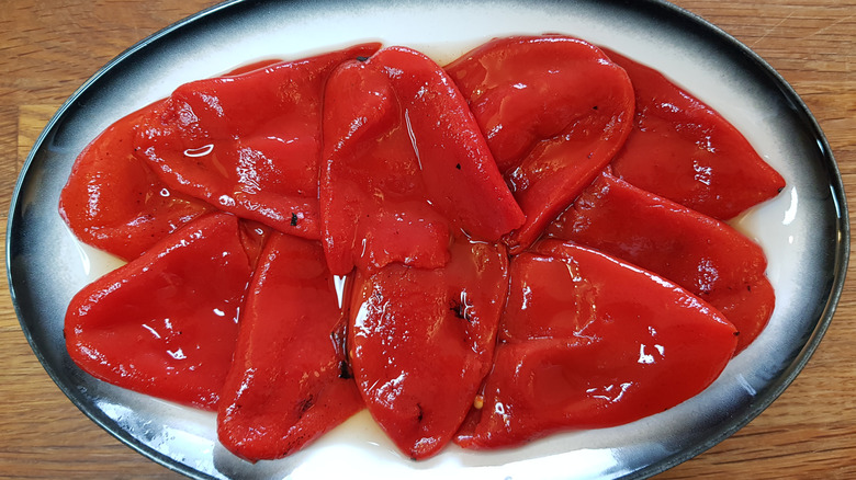 peeled roasted red peppers on a ceramic plate