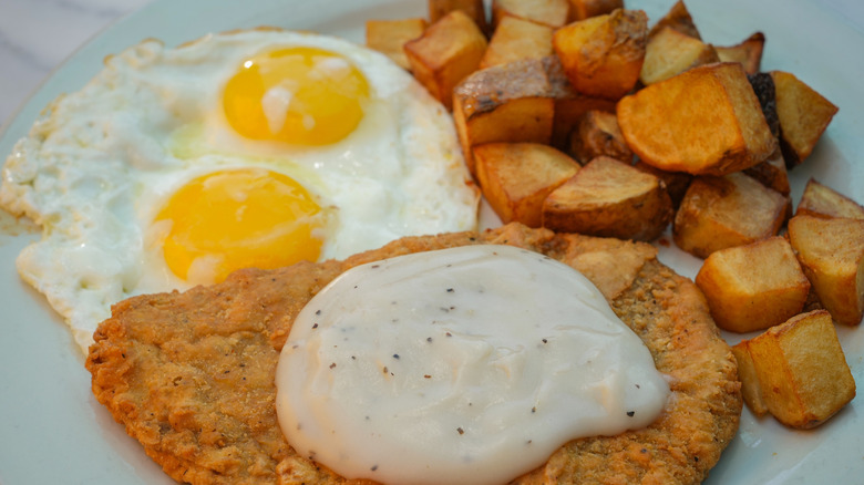 Chicken-fried cube steak with gravy, eggs, and potatoes