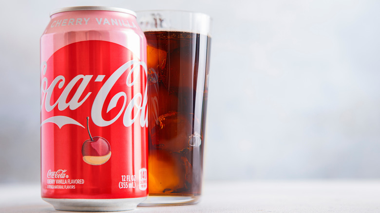 a can of Cherry Vanilla Coke with a soda filled glass behind it