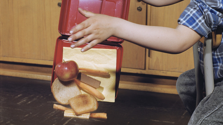 Food falls out of a 1950s-style lunchbox