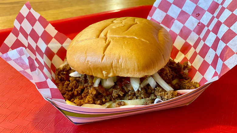 A Maid-Rite sandwich on a red tray lined with red checkered paper.