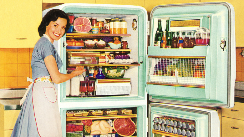 Mid century cook next to open fridge