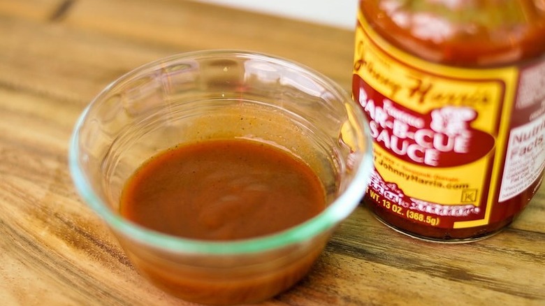 a bottle and small bowl of Johnny Harris Bar-B-Cue Sauce