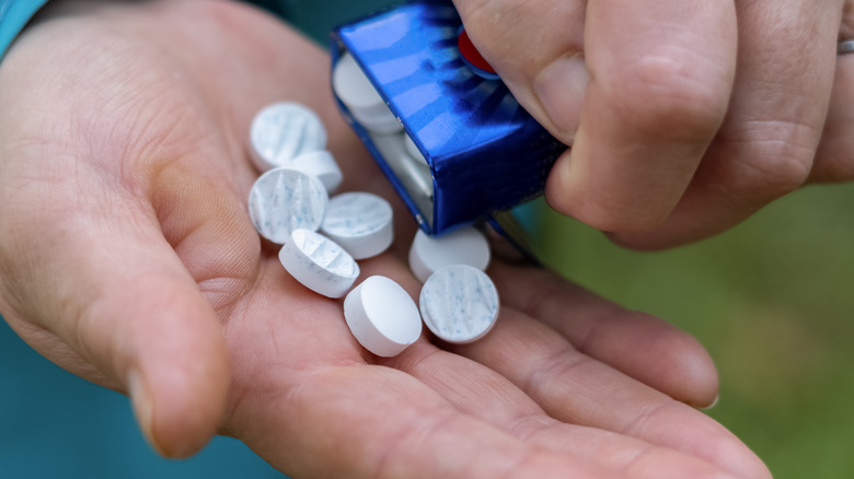 A person pouring out mints into their hand
