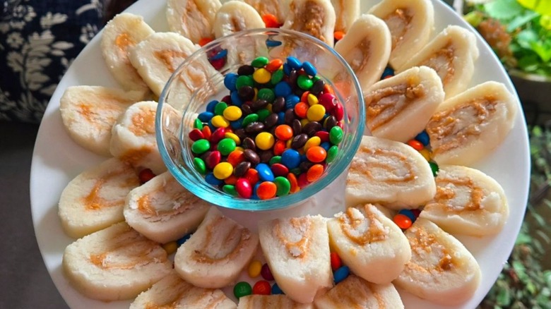 Potato candy slices centered around bowl of M&M candies