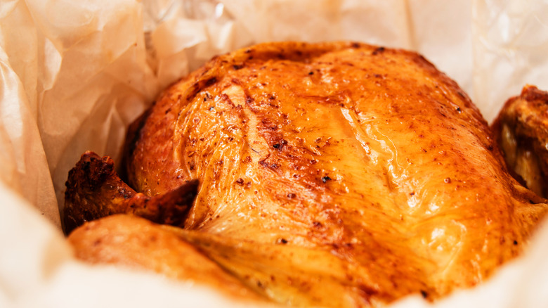 A whole chicken is cooked in a parchment cooking bag