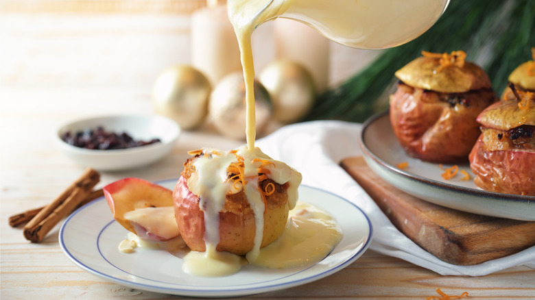 Pouring creme anglaise onto a baked apple dessert