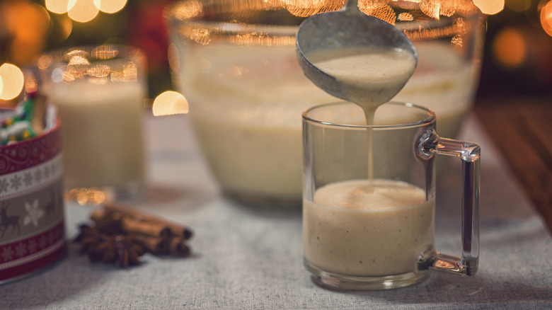 A ladle pouring eggnog into a cup