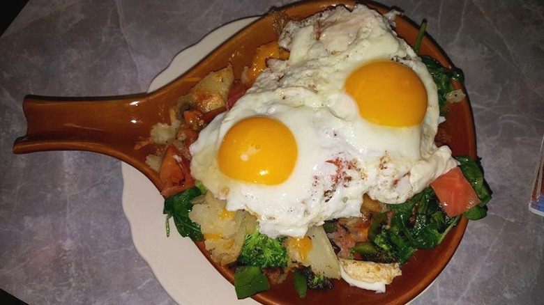 Skillet plate with veggies topped with two sunny side up eggs
