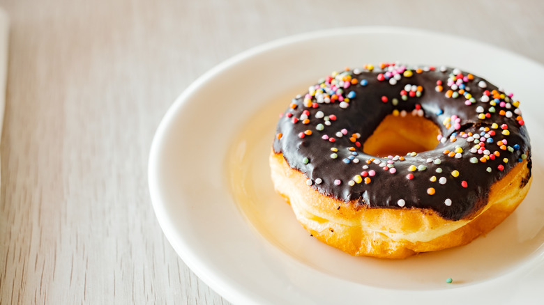 A spudnut donut coated in a chocolate glaze and sprinkles