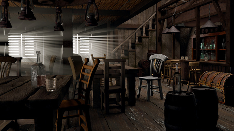 The interior of an old saloon with only some light coming in from the shuttered windows