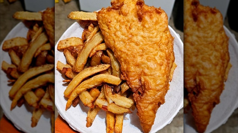 Paper plate with large crispy battered fish filet and pile of fries