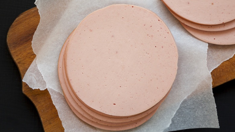 Slices of bologna on a wooden cutting board