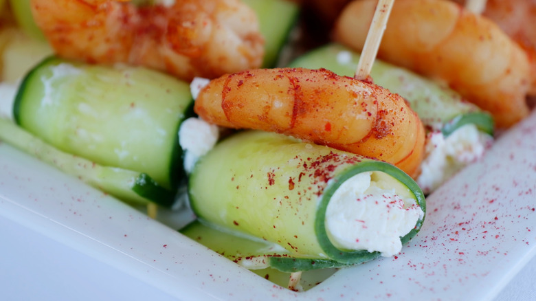 Shrimp cucumber canapés with cucumbers rolled over cream cheese and topped with shrimp.