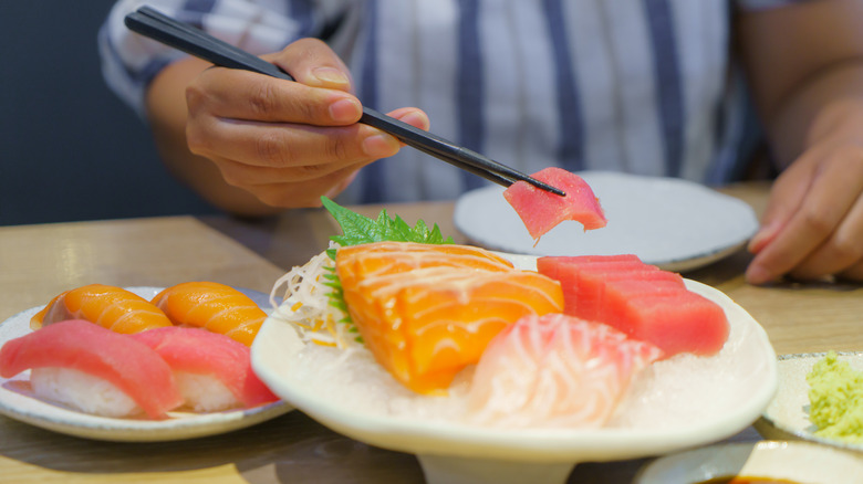 Chopsticks holding raw fish