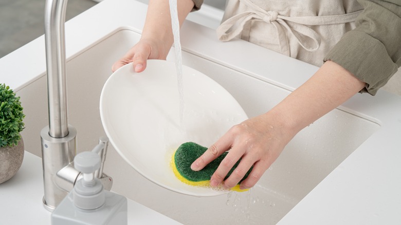Person washing plate.