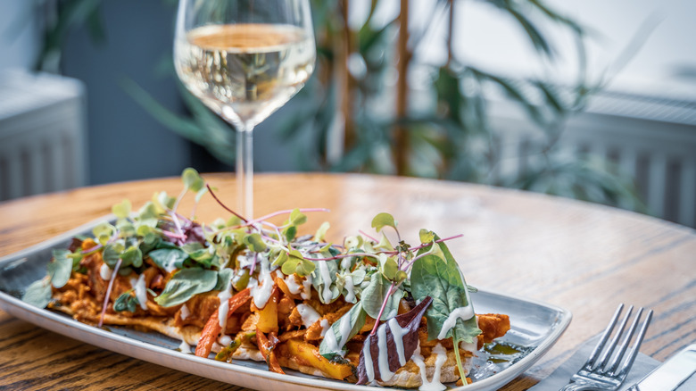 glass of white wine with spicy chicken dish