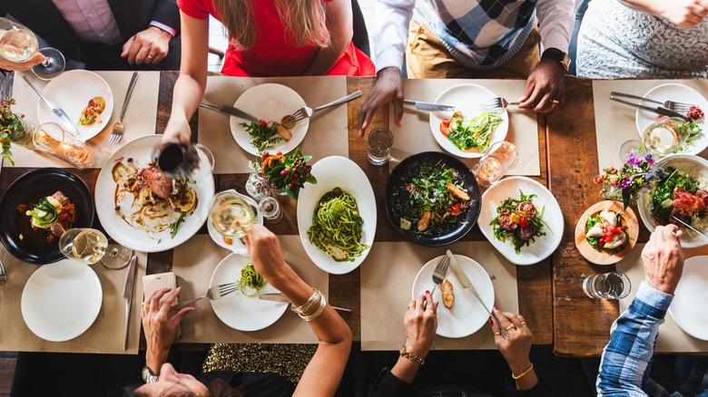 A gorgeous lunch spread of pastas, meat-based dishes, and more captured from above.