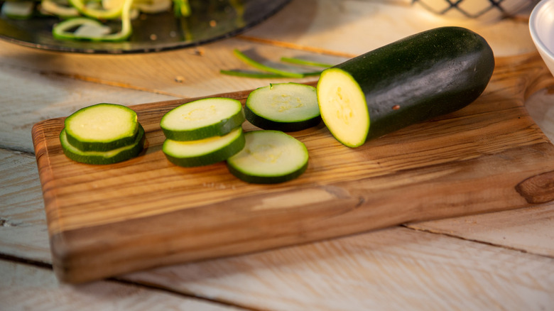 raw zucchini on wooden cutting board