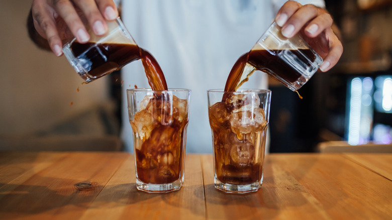 Person pouring cold brew over ice