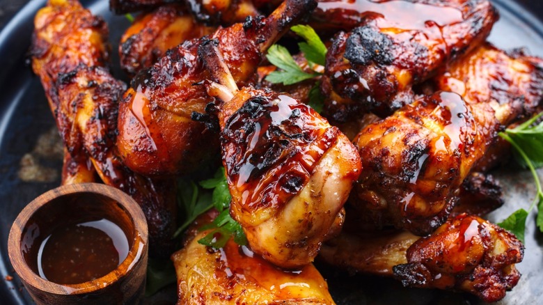 A plate of hot wings glazed in sauce.
