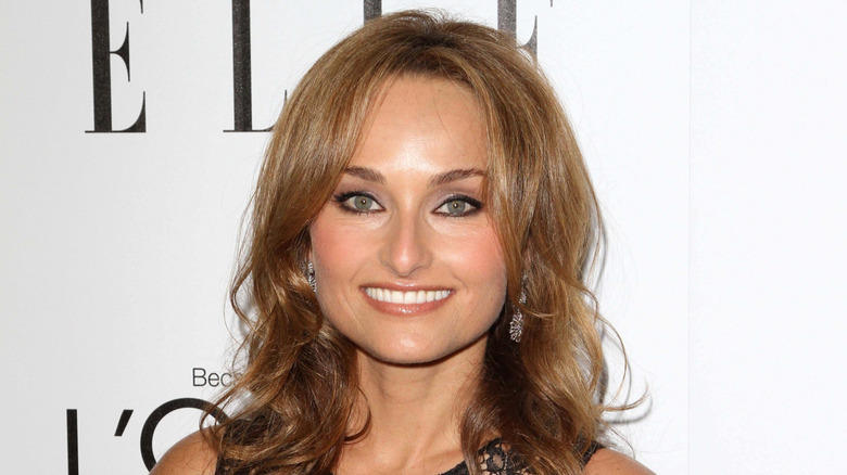 Giada de Laurentiis cooking in a kitchen with tile backsplash