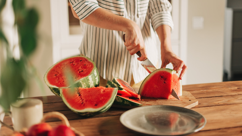 person cutting watermelon