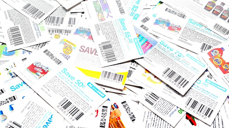 A large assortment of manufacturer coupons piled on top of one another