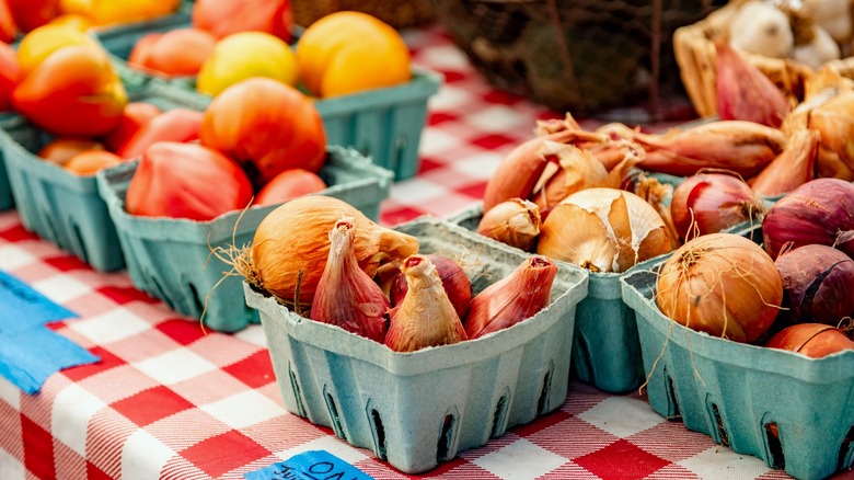 multiple types of onions at a farmer's market