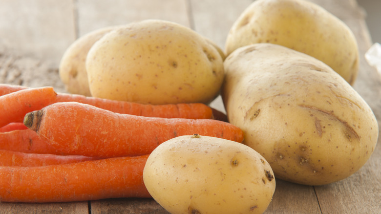 raw carrots and potatoes on a table