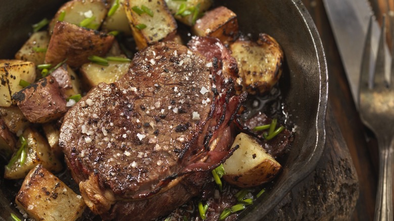 Seasoned steak in a skillet.