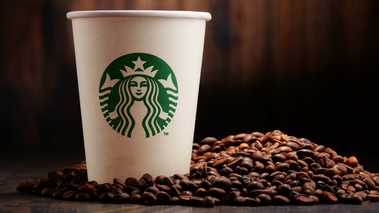 Starbucks cup in a pile of coffee beans