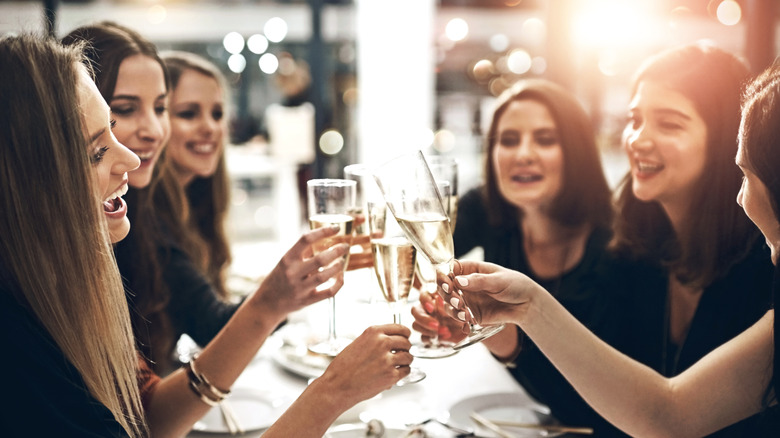 A table of women clinking glasses at a restaurant