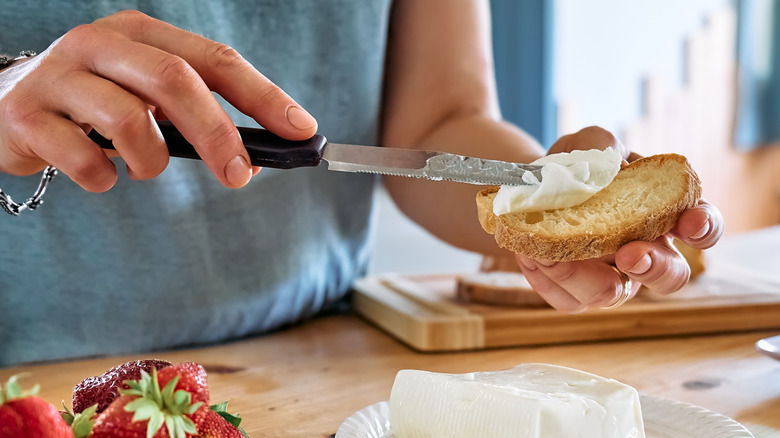 Spreading cheese on toast