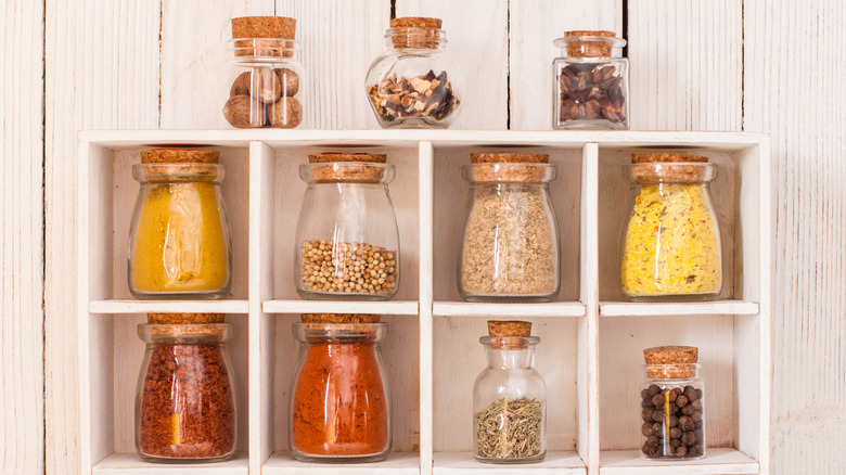 spices in glass jars in a wooden cubby