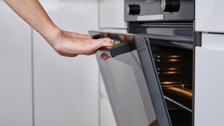 hands opening an oven door