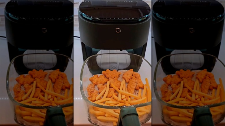 Dinosaur-shaped chicken nuggets and fries in a glass air fryer
