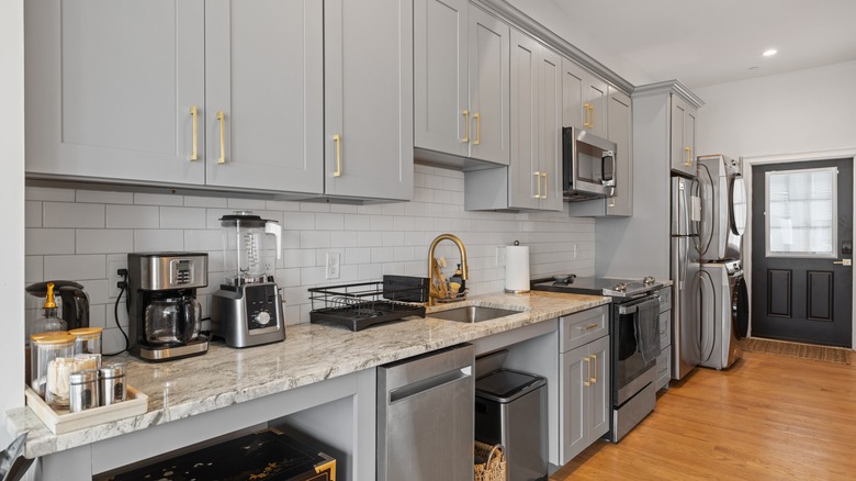 Kitchen with gray cabinetry and gold hardware