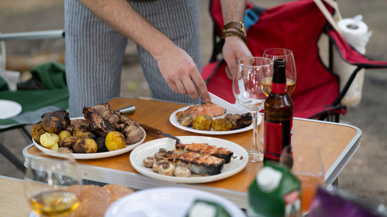 A man serving grilled food outside