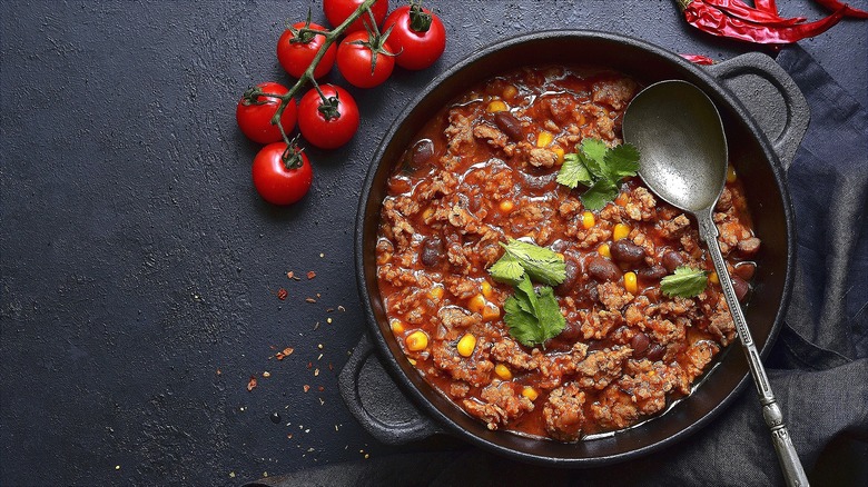 Beef chili with black beans and corn in a cast-iron pot