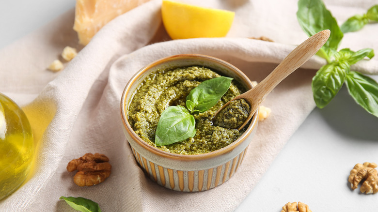 small bowl of fresh pesto with a wooden spoon