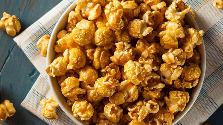 Caramel corn in a bowl on a beige tea towel