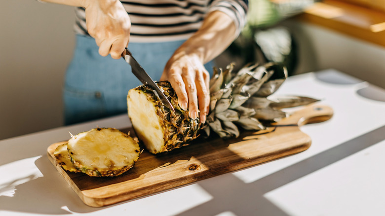 cutting whole pineapple