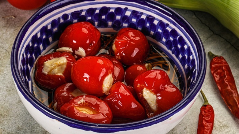 A blue and white bowl of feta-stuffed peppers.