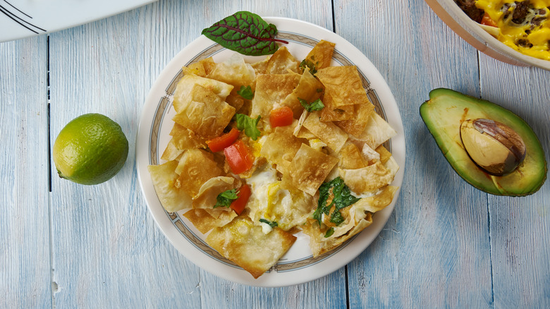 Plate of migas with avocados and lime on the side